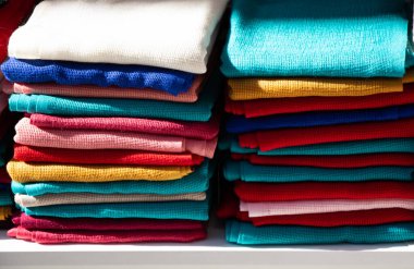 Bir pazarda çok renkli kumaş yığını.