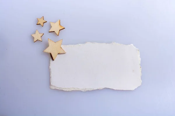 Pequeñas Estrellas Madera Colocadas Sobre Papel Roto Sobre Blanco —  Fotos de Stock