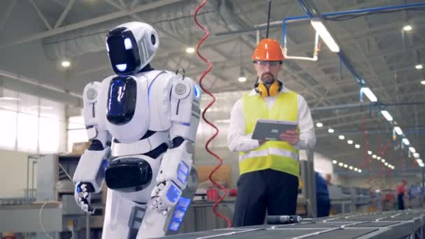 Mužské tovární zaměstnance je zapnutí robot po kterém snads nahoru a začíná vrtání — Stock video