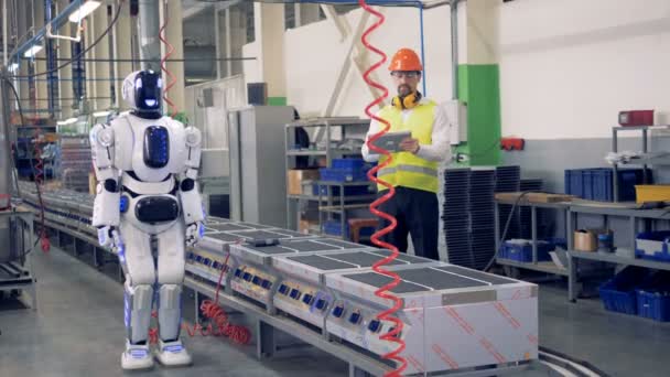 Human-like robot is getting switched on and allowed to start drilling by a factory worker — Stock Video