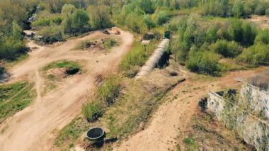 Bir adam bir motosiklet üzerinde bir büyük parça, üstten görünüm sürmek. Motocross yarışçılar toprak yolda.