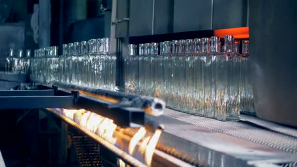 Стеклянные бутылки перемещаются с конвейерной ленты после сжигания — стоковое видео