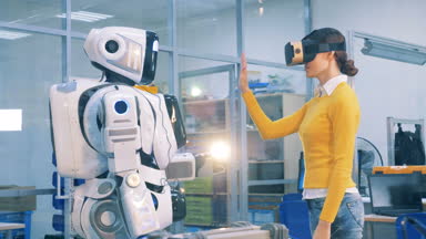 Sanal gözlüklü genç kadın bir insan benzeri robot bir el dokunuyor