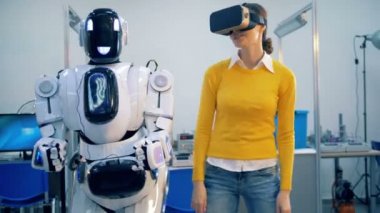 Genç bir dişi ve bir cyborg kendi elleri ve kalça içinde dans ederken synch hareket ediyor