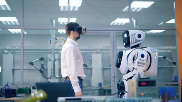 Male engineer and robotic humanoid are giving each other high-five — Stock Video