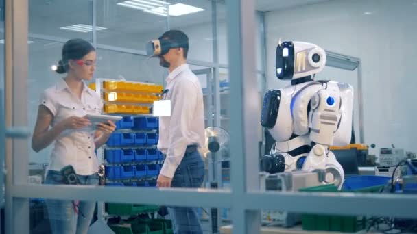 Человекоподобный робот копирует движения лаборанта под наблюдением — стоковое видео