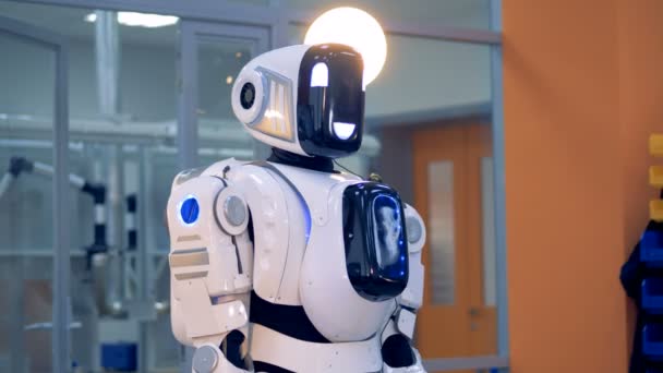 Голова роботів обертається навколо і назад з піднятою рукою — стокове відео