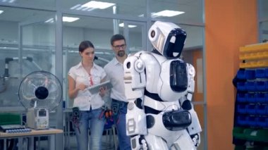 Kadın ve erkek bir robot birlikte test.