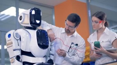 Erkek ve kadın bir amper metre bir robot üzerinde kullanmak.