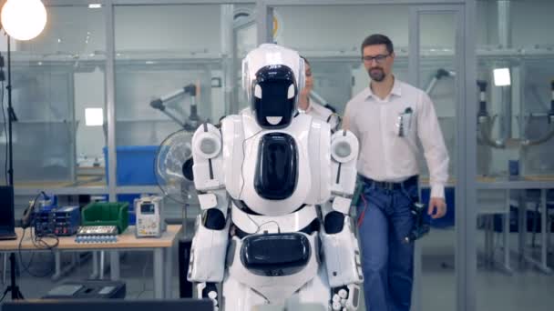 Mensen controleren een robot samen. — Stockvideo
