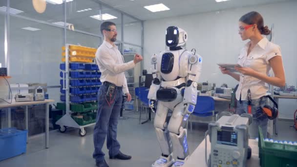 Een man bestellingen een robot om te zetten. — Stockvideo