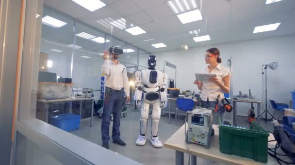 Человек в очках VR тестирует робота . — стоковое видео
