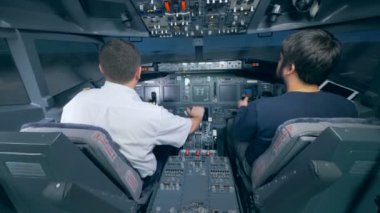 Uçan bir pilot ve bir sivil tarafından kontrol edilen bir uçuş simülatörü sürecinde