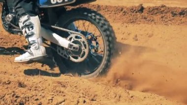 Motosiklet binici tozlu bir arazi ile çalışmaya başlama.