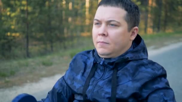 Gros plan d'un homme physiquement handicapé face tout en poussant la poignée des fauteuils roulants — Video