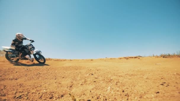 Motorcyklist driver sin cykel genom damm och sand i slow motion — Stockvideo