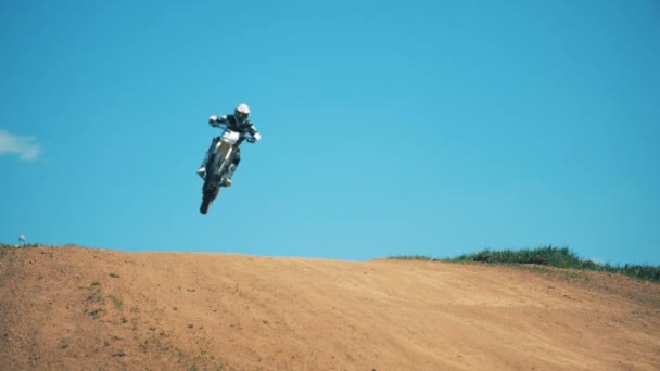 Un salto di un motociclista sulla sua moto su un terreno polveroso — Video Stock