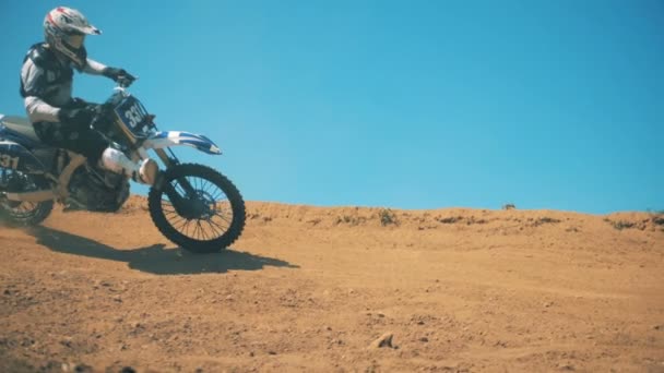 Мотоциклист выполняет трюк во время езды на мотоцикле по пыли — стоковое видео