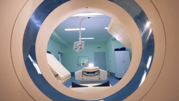 Переміщення через сканерний отвір томографічної машини в бік її ліжка і скануючих платформ — стокове відео