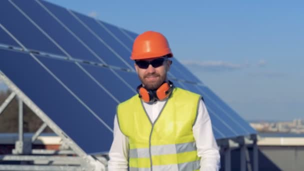 Der männliche Experte bewegt sich weg von einer Solarzelle und hebt seinen Helm. Alternatives Energiekonzept. — Stockvideo