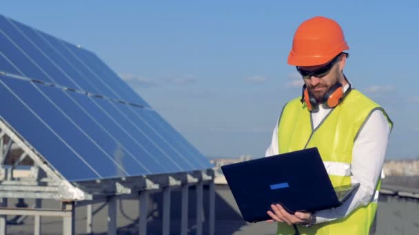 Batería solar y un constructor masculino trabajando con su portátil cerca. Ecología Concepto de Conservación de Energía . — Vídeos de Stock