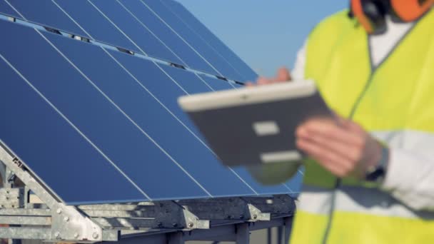 Conceito de energia verde. Close up de um computador tablet nas mãos de um construtor de módulos solares — Vídeo de Stock