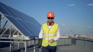 Bir güneş paneli ve onun kask kaldırarak bir mühendis ile çatı