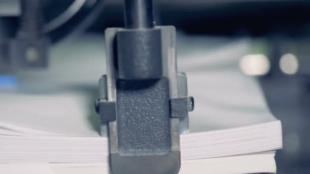 Metalen apparaat splitst papier in een print fabriek, close-up. Rij papier sorteren proces. — Stockvideo
