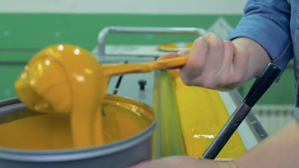 Ein Arbeiter bringt gelbe Farbe an einen speziellen Ort einer Fabrikausrüstung. 4k. — Stockvideo