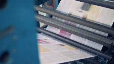 Yazdırılmış kağıtları hareket halinde bir konveyör, yakın çekim.