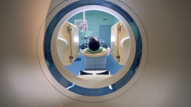 Male patient is moving into a CAT-scanner. Medical equipment: computed tomography machine in diagnostic clinic — Stock Video