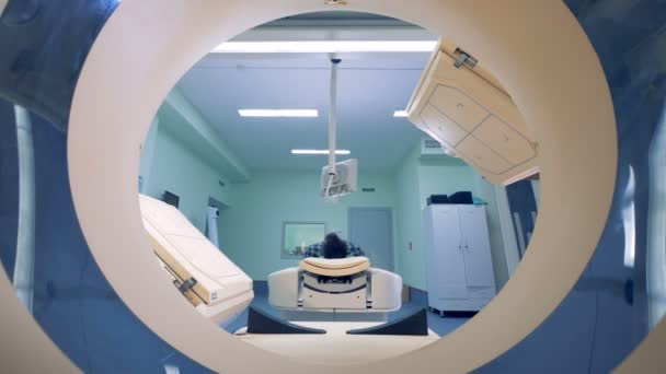 CAT-scanners table with a patient is lowering while the scanning platforms are getting ready to launch — Stock Video