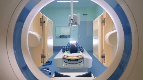 Medical scanning equipment and a male patient. Man lays in Magnetic Resonance Image device. — Stock Video