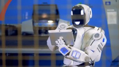 İnsan benzeri robot mekanize ekipman ile bir tablet bilgisayar kontrol ediyor
