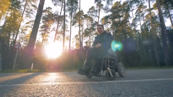 Un handicapé est assis dans un fauteuil roulant à l'extérieur — Video