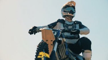 Donanımlı ve hazırlanmış binici açık havada statik motosikletine oturuyor