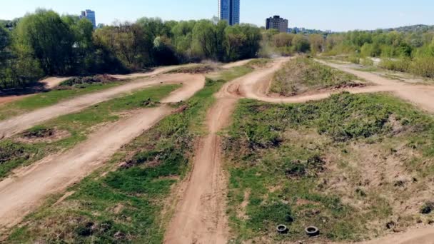 Vista de ângulo largo de uma pista de corrida com um piloto dirigindo através dele em sua motocicleta — Vídeo de Stock