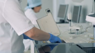 Hemşire bir modern laboratuvar özel makine yapılan testlerden sonra şişe örneklerini alır.