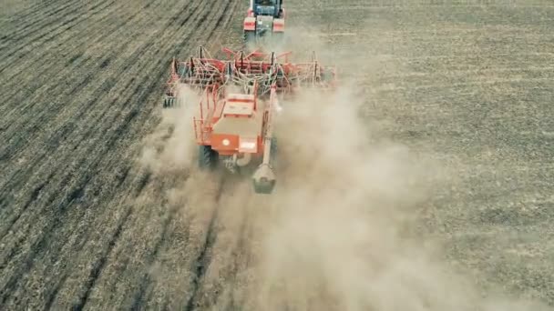 Een trekker volbrengt seizoensgebonden werken alvorens gewassen. Luchtfoto 4k. — Stockvideo