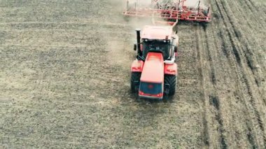 Bir römork ile kırmızı traktör olduğu bir alan üzerinde çalışma.