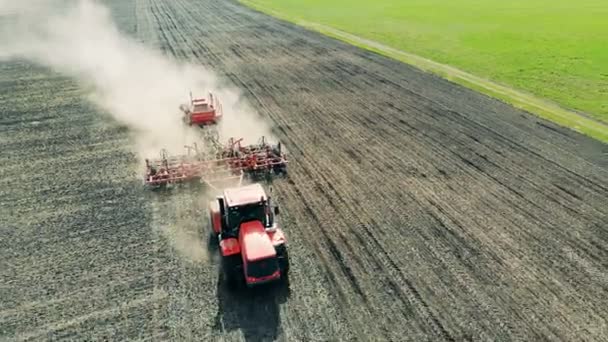 Tractor rojo araña el suelo para la siembra, vista superior . — Vídeo de stock