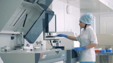 Kadın laboratuvar çalışan bir laboratuvar odada tıbbi malzeme ile çalışır.