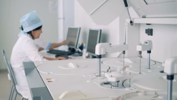 Trabajador de laboratorio pone muestras de sangre en una máquina para realizar pruebas. 4K . — Vídeos de Stock