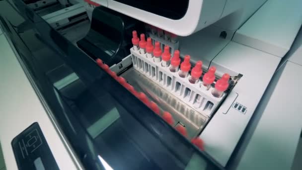 Tubos de amostra de plástico se movem em uma linha farmacêutica automatizada, de perto . — Vídeo de Stock