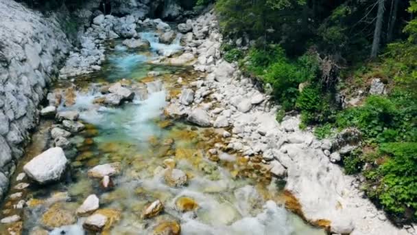 Καταρράκτη του νερού την άνοιξη που ρέει κάτω από τις πέτρες. Φρέσκο βουνίσιο νερό ρέει σε ολόκληρη την πέτρα. Εναέρια. — Αρχείο Βίντεο