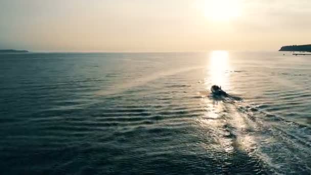 Schnellboot schwimmt bei Sonnenuntergang über offenes Wasser. — Stockvideo