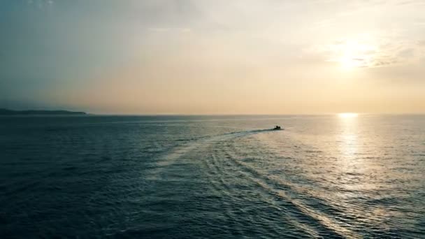 Zee op aunset wordt steeds doorkruist door een motorboot — Stockvideo