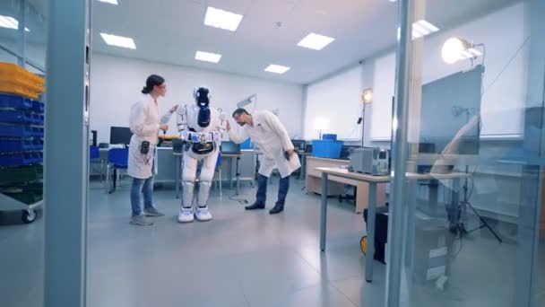 Engineers fixing robot. Robot in scientific lab. — Stock Video