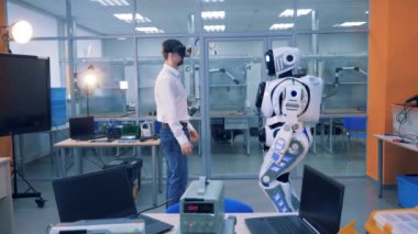 Erkek işçi ve robot bir odada el sıkışın. VR oyun kavramı.