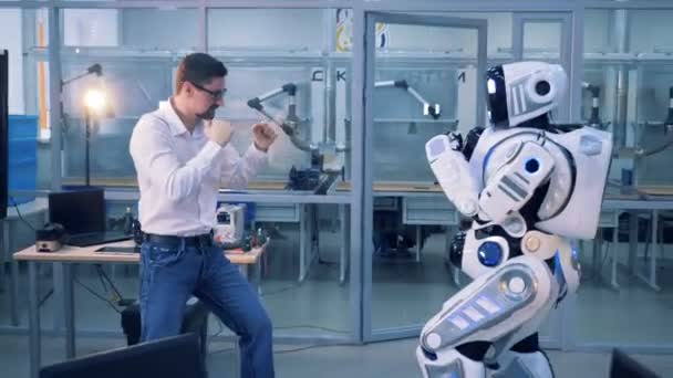 A droid and a man fighting in a room. — Stock Video